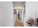 Hallway with wood floors, white walls, trim and doors with artwork lining the walls at 201 Eaglenook Way, Osprey, FL 34229