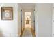 Hallway leading to bathroom with vanity; artwork on walls and wood floors at 201 Eaglenook Way, Osprey, FL 34229