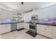 Bright kitchen with stainless steel appliances, black countertops, subway tile and white cabinets at 201 Eaglenook Way, Osprey, FL 34229