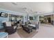 Enclosed back patio featuring comfortable seating, wicker furniture, ceiling fans, and access to the home at 201 Eaglenook Way, Osprey, FL 34229