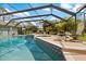 Inviting screened-in pool with spa, lounge chairs and tropical landscaping at 201 Eaglenook Way, Osprey, FL 34229