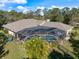 Aerial view of a large screened pool with a lush green lawn surrounded by mature landscaping and a privacy fence at 201 Eaglenook Way, Osprey, FL 34229