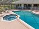 A view of the inviting pool and spa with a safety fence and covered lanai area at 201 Eaglenook Way, Osprey, FL 34229