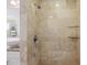 Walk-in shower featuring decorative tile surround, glass shelving, and a chrome shower head at 201 Eaglenook Way, Osprey, FL 34229