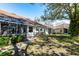 Backyard view of the property with screened lanai, mature trees, and well-maintained landscaping at 2123 Lynx Run, North Port, FL 34288