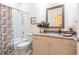 Bright bathroom featuring a shower-tub combo, granite countertop, and decorative mirror at 2123 Lynx Run, North Port, FL 34288