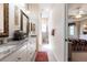 Well-lit bathroom featuring double sinks, granite counters, and doorway to bedroom at 2123 Lynx Run, North Port, FL 34288