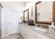 Spacious bathroom with double sinks, granite counters, and decorative mirrors at 2123 Lynx Run, North Port, FL 34288