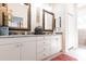Bathroom vanity featuring double sinks, decorative mirrors, and granite countertop at 2123 Lynx Run, North Port, FL 34288