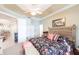 Bright bedroom featuring tray ceiling, neutral walls, and patterned bedding at 2123 Lynx Run, North Port, FL 34288