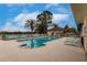 Community pool with lounge chairs offering a relaxing outdoor experience with palm trees and a scenic backdrop at 2123 Lynx Run, North Port, FL 34288