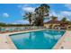 Large community pool surrounded by lounge chairs, palm trees, and serene views at 2123 Lynx Run, North Port, FL 34288