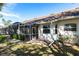 Rear exterior view of home with screened patio and lush backyard featuring a well-manicured lawn at 2123 Lynx Run, North Port, FL 34288
