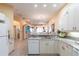 Bright kitchen with white cabinets, granite countertops, and breakfast bar at 2123 Lynx Run, North Port, FL 34288