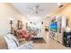Cozy living room with tile floors, ceiling fan, and open floor plan offers ample natural light at 2123 Lynx Run, North Port, FL 34288