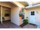 Cozy front porch with decorative flower pots, arched window, and brick flooring, creating a welcoming entrance at 2123 Lynx Run, North Port, FL 34288