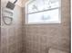 Tile shower stall featuring a window, bench, and modern fixtures at 2123 Lynx Run, North Port, FL 34288