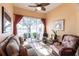 Bright sunroom with a beautiful view of the lake, featuring comfortable seating and tiled floors at 2123 Lynx Run, North Port, FL 34288