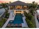 Enjoy a luxurious outdoor oasis with a sparkling pool, spa, and inviting lounge chairs for relaxation at 242 Oak Ave, Anna Maria, FL 34216