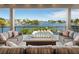 Waterfront balcony featuring comfortable seating, gas fire pit, and open water views at 242 Oak Ave, Anna Maria, FL 34216