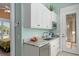 Entertaining bar area features custom cabinets, a sink, a microwave and access to the outdoors at 242 Oak Ave, Anna Maria, FL 34216