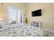 Bright bedroom features two twin beds with sea-themed bedding and a wall-mounted TV at 242 Oak Ave, Anna Maria, FL 34216