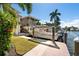 Beautiful home featuring a boat dock with lift and meticulous landscaping at 242 Oak Ave, Anna Maria, FL 34216