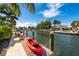 Dockside view featuring an orange kayak and peaceful canal waters under a sunny sky at 242 Oak Ave, Anna Maria, FL 34216