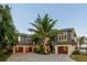 Stunning multi-level home featuring private garages, lush landscaping, and an inviting facade at 242 Oak Ave, Anna Maria, FL 34216