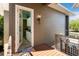 Exterior view showing the entrance from a deck, outdoor lighting, and view through open door to kitchen at 242 Oak Ave, Anna Maria, FL 34216
