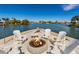 Relax by the waterfront fire pit with comfortable seating and scenic views at 242 Oak Ave, Anna Maria, FL 34216