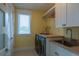 Bright laundry room features a sink, washer, dryer, storage, and a window bringing in natural light at 242 Oak Ave, Anna Maria, FL 34216