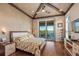 Cozy main bedroom boasts wood floors, vaulted ceilings, and a slider to an outdoor deck at 242 Oak Ave, Anna Maria, FL 34216