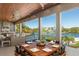 Outdoor dining area with waterfront views, outdoor kitchen, and nearby lounge area at 242 Oak Ave, Anna Maria, FL 34216
