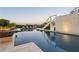 Resort-style pool with stylish lounge chairs, water feature, and tropical foliage at 242 Oak Ave, Anna Maria, FL 34216