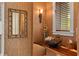 Chic powder room featuring a unique live edge wood counter and bamboo framed mirror at 242 Oak Ave, Anna Maria, FL 34216