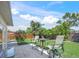 Charming backyard patio area featuring a tile patio with a table and chairs, with a well-maintained lawn and privacy fence at 2427 Tulip St, Sarasota, FL 34239