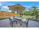 Cozy backyard patio with a shaded table and chairs, perfect for outdoor dining and relaxation, surrounded by a wooden fence at 2427 Tulip St, Sarasota, FL 34239