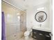 Updated bathroom with sleek glass enclosed shower, modern vanity, and circular mirror at 2427 Tulip St, Sarasota, FL 34239