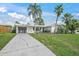 Inviting single-story home featuring a long driveway and lush, green landscaping at 2427 Tulip St, Sarasota, FL 34239