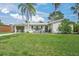 Charming single-story home with a well-manicured front yard and mature palm trees at 2427 Tulip St, Sarasota, FL 34239