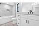 Modern bathroom featuring white marble tiling, white vanity, and a shower and tub at 2640 Geneva Rd, Venice, FL 34293