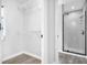 Open view from closet to a sleek tiled bathroom featuring a glass enclosed shower at 2640 Geneva Rd, Venice, FL 34293