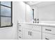 Close up of a bright bathroom featuring a sleek vanity with marble countertops and sleek black fixtures at 2640 Geneva Rd, Venice, FL 34293