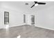 Bright bedroom with sleek flooring, modern ceiling fan, and a view to the walk-in closet and additional rooms at 2640 Geneva Rd, Venice, FL 34293