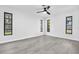 Bright bedroom features modern ceiling fan, luxury vinyl flooring, and windows letting in natural light at 2640 Geneva Rd, Venice, FL 34293