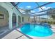 A stunning screened-in pool featuring a tranquil waterfall and inviting design at 2640 Geneva Rd, Venice, FL 34293