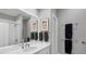 Bright bathroom with white vanity, framed mirror, grey walls, and chrome towel racks at 3008 Highlands Bridge Rd, Sarasota, FL 34235