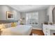Comfortable bedroom with hardwood floors, neutral decor, and ample natural light from shuttered windows at 3008 Highlands Bridge Rd, Sarasota, FL 34235