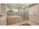 Bathroom featuring a large soaking tub, glass-enclosed shower, and tile flooring at 3040 Grand Bay Blvd # 234, Longboat Key, FL 34228